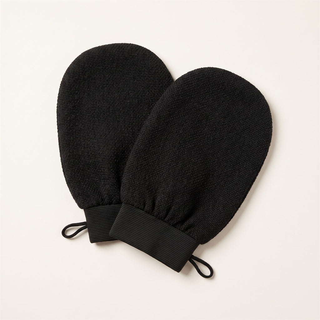 Pair of black Korean exfoliating bath mitts on an off-white background